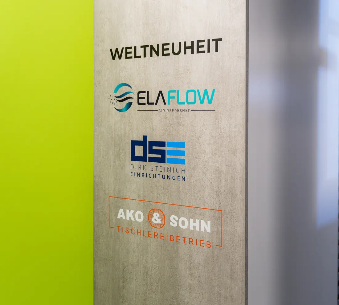 Standwand mit ELAFLOW, DSE und AKO & Sohn unter dem Schriftzug Weltneuheit